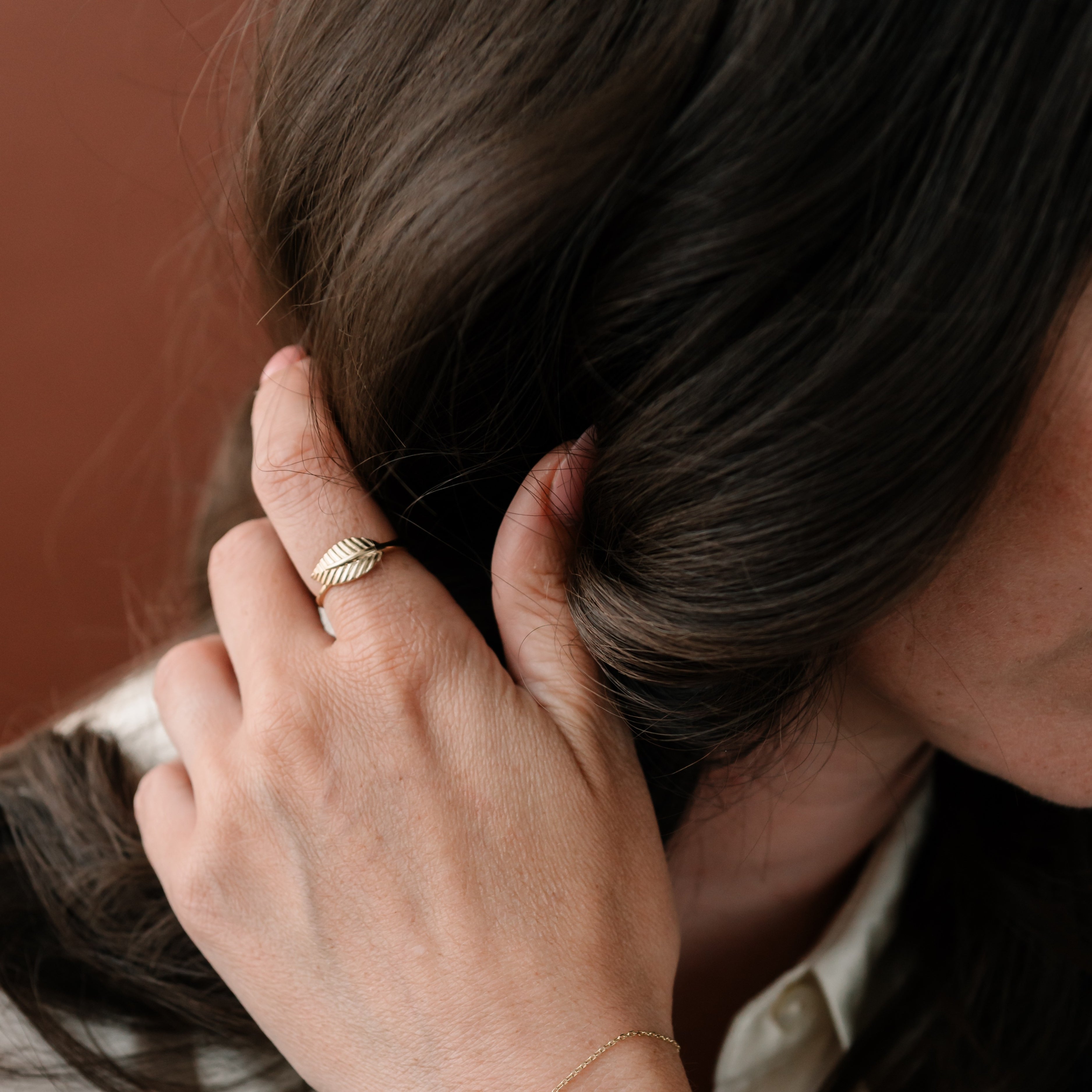 Zlatý prsten FOLIA s motivem listu – přírodní elegance a ženský styl na ruce modelky