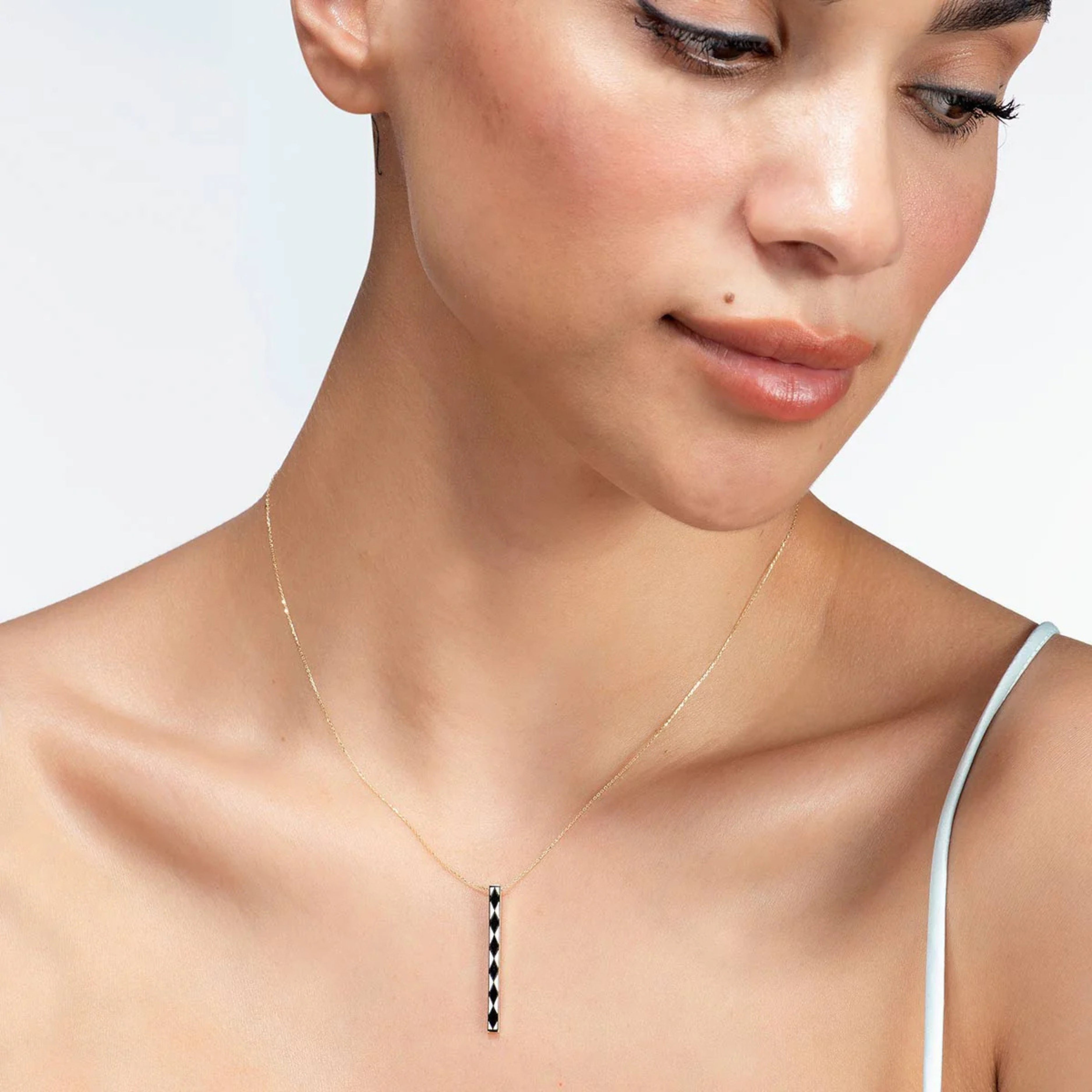 Modelka s elegantným zlatým náhrdelníkom CREYO NOIR s čiernymi vzormi