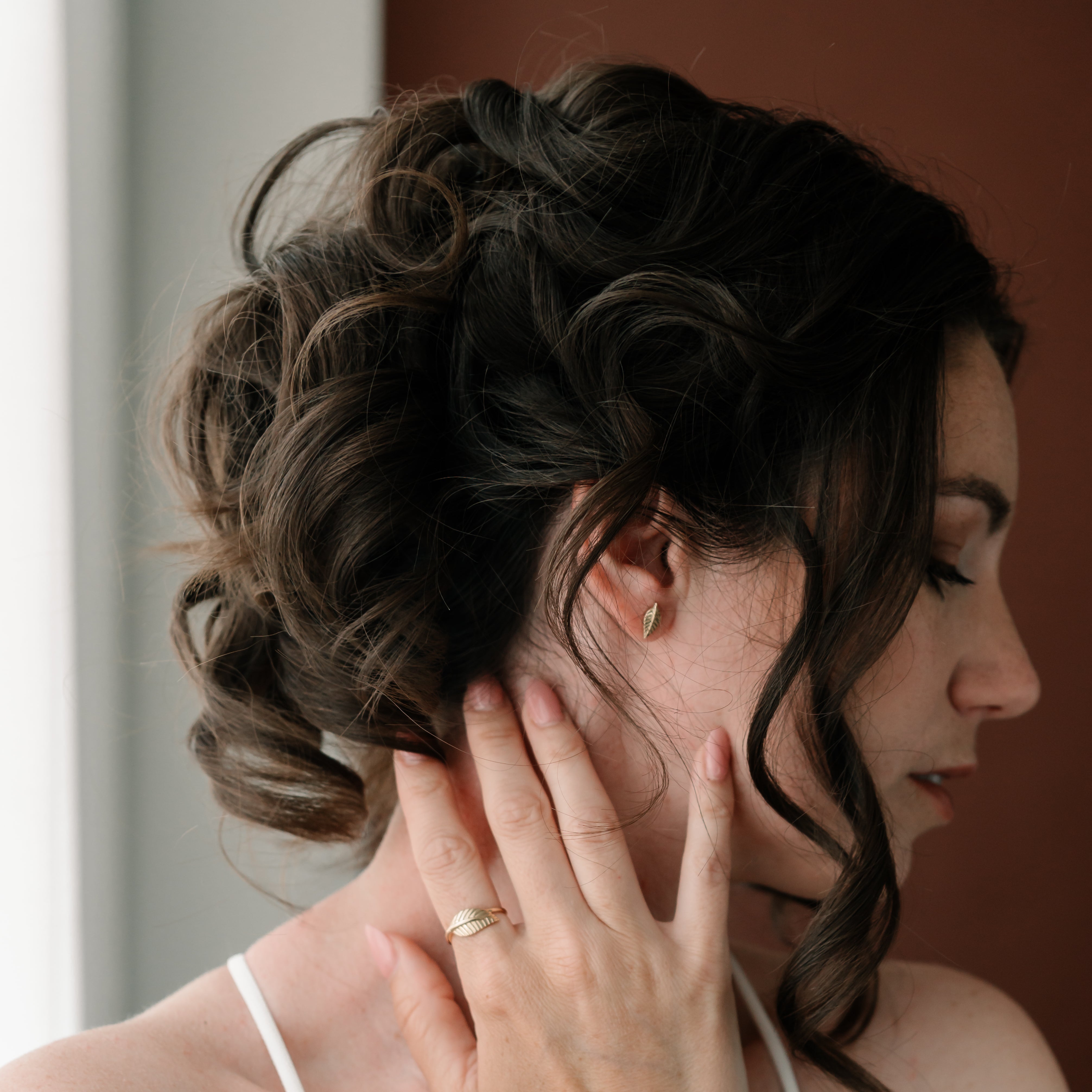 Zlaté náušnice FOLIA ve tvaru listu – elegantní vzhled na ženském uchu