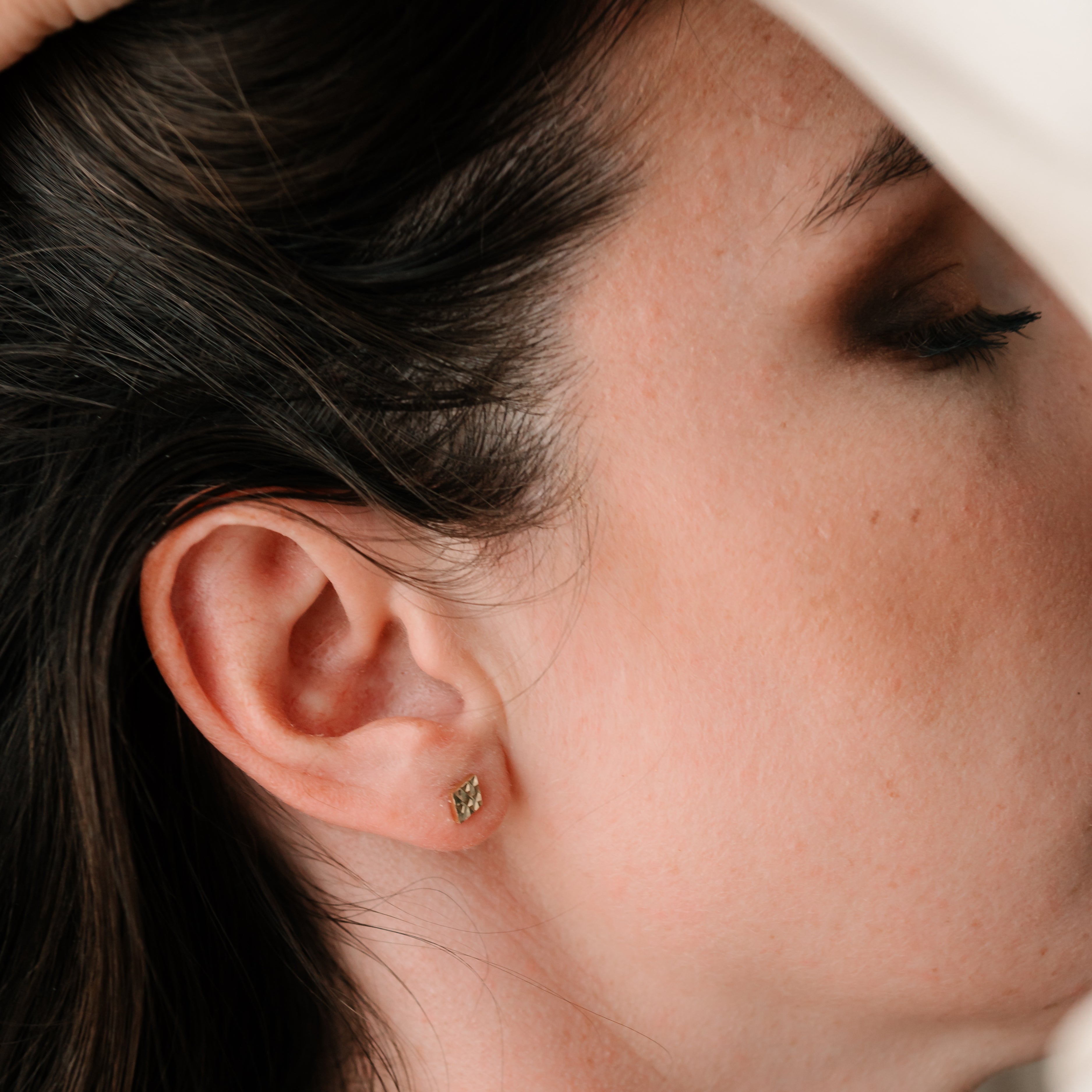 Zlaté náušnice ASTRA s geometrickým vzorem – elegantní a moderní vzhled na ženském uchu